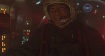 Movie still from “Godzilla vs. Mechagodzilla II” (1993), directed by Kazuki Ômori – A man in a helmet smiles for the camera; Medium shot, Low angle