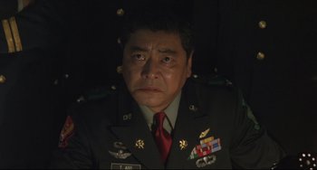 Movie still from “Godzilla vs. Mechagodzilla II” (1993), directed by Kazuki Ômori – A man in a military uniform stares into the camera; Close Up shot, Low angle