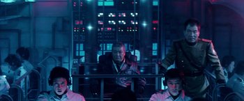 Movie still from “Godzilla: Final Wars” (2004), directed by Koji Hashimoto – A man sitting in a chair in front of a window; Medium shot, Low angle