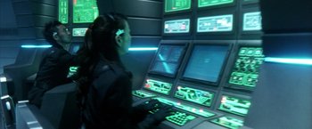 Movie still from “Godzilla: Final Wars” (2004), directed by Koji Hashimoto – A woman is sitting in front of a computer screen; Medium shot, High angle