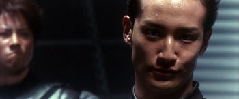 Movie still from “Godzilla: Final Wars” (2004), directed by Koji Hashimoto – A person wearing a black shirt; Close Up shot, Low angle