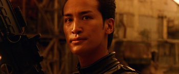 Movie still from “Godzilla: Final Wars” (2004), directed by Koji Hashimoto – A person wearing a black jacket; Close Up shot, Low angle