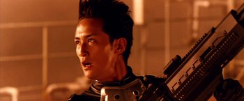 Movie still from “Godzilla: Final Wars” (2004), directed by Koji Hashimoto – A person holding a gun; Close Up shot, Low angle