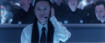 Movie still from “Godzilla: Final Wars” (2004), directed by Koji Hashimoto – A person with a headset on in front of a computer screen; Close Up shot, Low angle