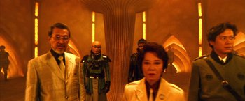 Movie still from “Godzilla: Final Wars” (2004), directed by Koji Hashimoto – A group of people standing next to each other in a hallway; Wide shot, Low angle
