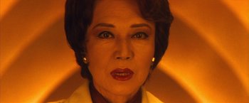 Movie still from “Godzilla: Final Wars” (2004), directed by Koji Hashimoto – An older woman with short brown hair wearing a white shirt; Close Up shot, Low angle