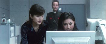 Movie still from “Godzilla: Final Wars” (2004), directed by Koji Hashimoto – Two women and a man looking at a computer screen; Medium shot, Low angle