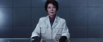 Movie still from “Godzilla: Final Wars” (2004), directed by Koji Hashimoto – A woman in a white jacket and black gloves; Medium shot, Low angle