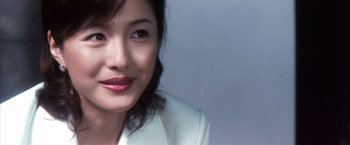 Movie still from “Godzilla: Final Wars” (2004), directed by Koji Hashimoto – A person wearing a white jacket; Close Up shot, Over the shoulder angle