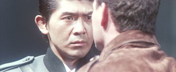 Movie still from “Godzilla: Final Wars” (2004), directed by Koji Hashimoto – A person looking at a mirror; Close Up shot, Over the shoulder angle