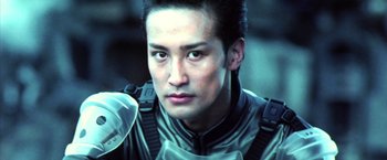 Movie still from “Godzilla: Final Wars” (2004), directed by Koji Hashimoto – A person wearing a suit; Close Up shot, Low angle