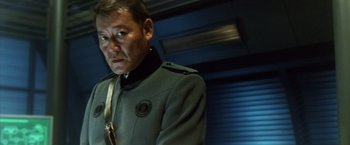 Movie still from “Godzilla: Final Wars” (2004), directed by Koji Hashimoto – A man in a uniform standing next to a wall; Close Up shot, Low angle