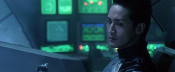 Movie still from “Godzilla: Final Wars” (2004), directed by Koji Hashimoto – A man in a control room looking into the distance; Close Up shot, Over the shoulder angle