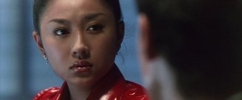 Movie still from “Godzilla: Final Wars” (2004), directed by Koji Hashimoto – A woman in a red jacket looking at a man in a black suit; Close Up shot, Over the shoulder angle