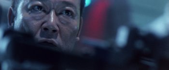 Movie still from “Godzilla: Final Wars” (2004), directed by Koji Hashimoto – A man's face in a dark room; Close Up shot, Low angle
