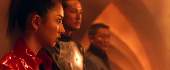 Movie still from “Godzilla: Final Wars” (2004), directed by Koji Hashimoto – A group of people standing next to each other in a room; Close Up shot, Over the shoulder angle