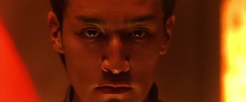 Movie still from “Godzilla: Final Wars” (2004), directed by Koji Hashimoto – A man's face in a dimly - lit room; Extreme Close Up shot, Low angle