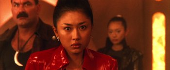 Movie still from “Godzilla: Final Wars” (2004), directed by Koji Hashimoto – A woman in a red jacket looking at the camera; Close Up shot, Low angle