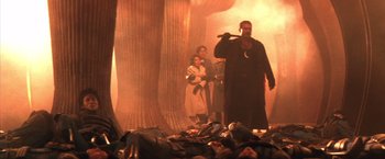 Movie still from “Godzilla: Final Wars” (2004), directed by Koji Hashimoto – A group of people standing in a room with trees; Wide shot, Low angle