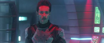 Movie still from “Godzilla: Final Wars” (2004), directed by Koji Hashimoto – A man in a futuristic suit is standing in the dark; Close Up shot, Low angle