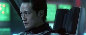 Movie still from “Godzilla: Final Wars” (2004), directed by Koji Hashimoto – A man sitting in a car looking off to the side; Close Up shot, Low angle