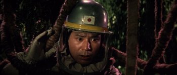 Movie still from “Godzilla: Tokyo S.O.S.” (2003), directed by Takao Okawara – A man wearing a helmet and holding on to a rope; Close Up shot, Low angle