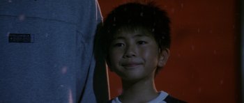 Movie still from “Godzilla: Tokyo S.O.S.” (2003), directed by Takao Okawara – A young boy is smiling for the camera; Close Up shot, High angle