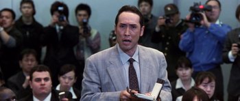 Movie still from “Godzilla: Tokyo S.O.S.” (2003), directed by Takao Okawara – A man in a suit and tie holding a notebook; Close Up shot, Low angle