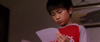 Movie still from “Godzilla: Tokyo S.O.S.” (2003), directed by Takao Okawara – A young boy holding a piece of paper in his hands; Close Up shot, Low angle