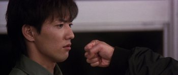 Movie still from “Godzilla: Tokyo S.O.S.” (2003), directed by Takao Okawara – A man with his fist up to his face; Extreme Close Up shot, Over the shoulder angle