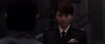 Movie still from “Godzilla: Tokyo S.O.S.” (2003), directed by Takao Okawara – A woman in a military uniform is looking at the camera; Close Up shot, Over the shoulder angle
