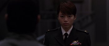 Movie still from “Godzilla: Tokyo S.O.S.” (2003), directed by Takao Okawara – A woman in a military uniform is looking at the camera; Close Up shot, Over the shoulder angle