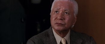 Movie still from “Godzilla: Tokyo S.O.S.” (2003), directed by Takao Okawara – An older man wearing a suit and tie; Close Up shot, Low angle