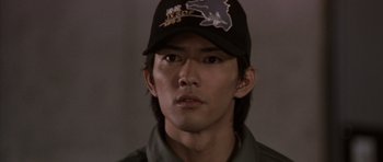 Movie still from “Godzilla: Tokyo S.O.S.” (2003), directed by Takao Okawara – A man wearing a baseball cap and a green shirt; Close Up shot, High angle