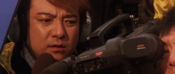 Movie still from “Godzilla: Tokyo S.O.S.” (2003), directed by Takao Okawara – A man with headphones is looking at a camera; Extreme Close Up shot, Low angle