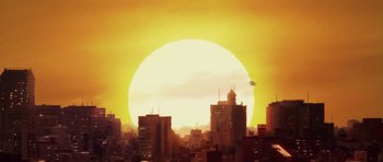 Movie still from “Godzilla: Tokyo S.O.S.” (2003), directed by Takao Okawara – The sun is setting over a city skyline; Extreme Wide shot, Low angle