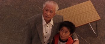 Movie still from “Godzilla: Tokyo S.O.S.” (2003), directed by Takao Okawara – An older man standing next to a younger man; Medium shot, Low angle
