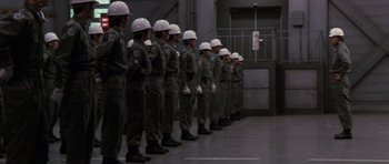 Movie still from “Godzilla: Tokyo S.O.S.” (2003), directed by Takao Okawara – A line of men in army fatigues and white helmets; Wide shot, Low angle