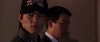 Movie still from “Godzilla: Tokyo S.O.S.” (2003), directed by Takao Okawara – Two men in suits and hats are looking at the camera; Close Up shot, Over the shoulder angle