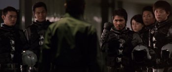 Movie still from “Godzilla: Tokyo S.O.S.” (2003), directed by Takao Okawara – A man standing next to another man in a suit; Medium shot, Over the shoulder angle