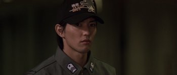 Movie still from “Godzilla: Tokyo S.O.S.” (2003), directed by Takao Okawara – A man wearing a baseball cap and a uniform; Close Up shot, Low angle