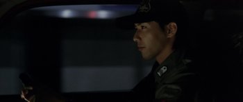 Movie still from “Godzilla: Tokyo S.O.S.” (2003), directed by Takao Okawara – A man wearing a hat sitting in a car; Close Up shot, Low angle