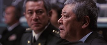 Movie still from “Godzilla: Tokyo S.O.S.” (2003), directed by Takao Okawara – Two men in military uniforms are looking at something; Close Up shot, Over the shoulder angle