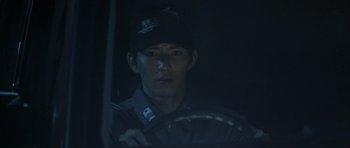 Movie still from “Godzilla: Tokyo S.O.S.” (2003), directed by Takao Okawara – A man sitting in a car in the dark holding a steering wheel; Close Up shot, Low angle