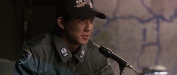 Movie still from “Godzilla: Tokyo S.O.S.” (2003), directed by Takao Okawara – A man wearing a baseball cap is talking into a microphone; Close Up shot, Low angle