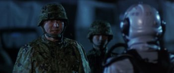 Movie still from “Godzilla: Tokyo S.O.S.” (2003), directed by Takao Okawara – A group of men standing next to each other wearing helmets; Close Up shot, Over the shoulder angle