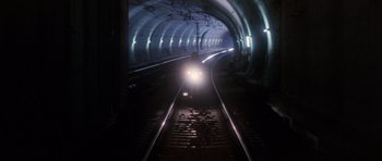 Movie still from “Godzilla: Tokyo S.O.S.” (2003), directed by Takao Okawara – A car is driving down the train tracks in a tunnel; Extreme Wide shot, High angle