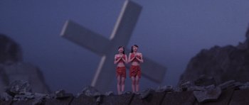 Movie still from “Godzilla: Tokyo S.O.S.” (2003), directed by Takao Okawara – A couple of women standing next to each other in front of a cross; Extreme Wide shot, Low angle