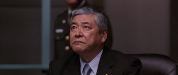 Movie still from “Godzilla: Tokyo S.O.S.” (2003), directed by Takao Okawara – An older man in a suit and tie looking off into the distance; Close Up shot, Low angle