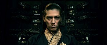 Movie still from “Goemon” (2009), directed by Kazuaki Kiriya – A man with long black hair wearing a black and gold shirt; Close Up shot, Low angle